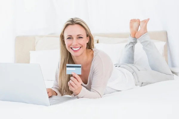 Blonde shopping online on the bed — Stock Photo, Image