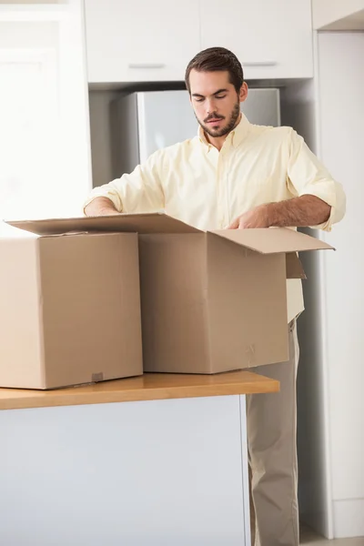 Hombre desempacando cajas en cocina —  Fotos de Stock