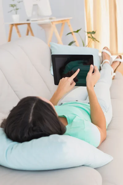 Brunette using her tablet on sofa — Stock Photo, Image