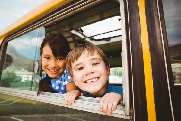 Mignonnes élèves souriant à la caméra dans le bus scolaire — Photo