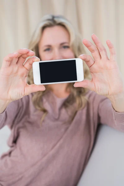 Blondin visar skärmen av smartphone — Stockfoto