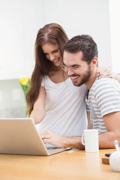 Couple smiling and using laptop — Stock Photo, Image