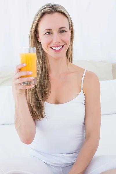 Блондинка держит стакан апельсинового сока — стоковое фото