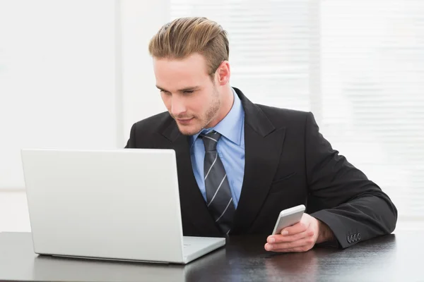 Uomo d'affari che utilizza laptop e telefono — Foto Stock