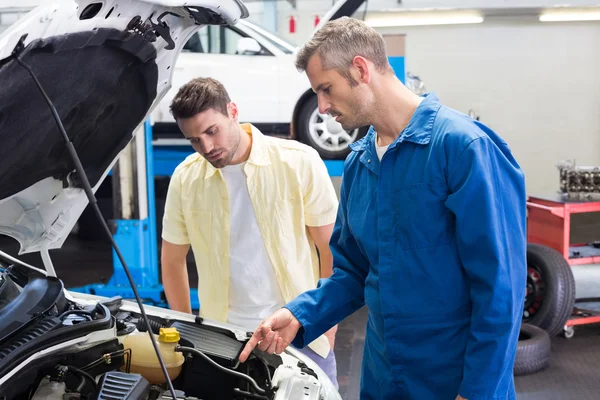 Mechanic showing customer the problem with car — Stock Photo, Image