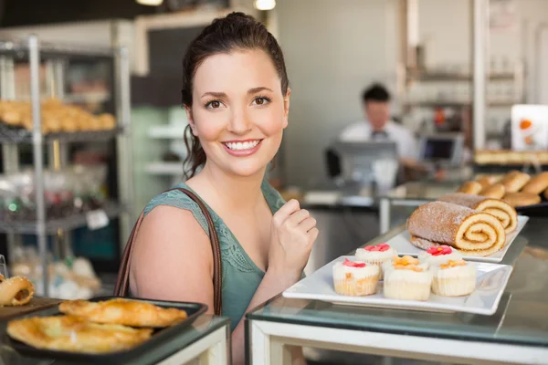 Mooie brunette kijken naar gebak — Stockfoto