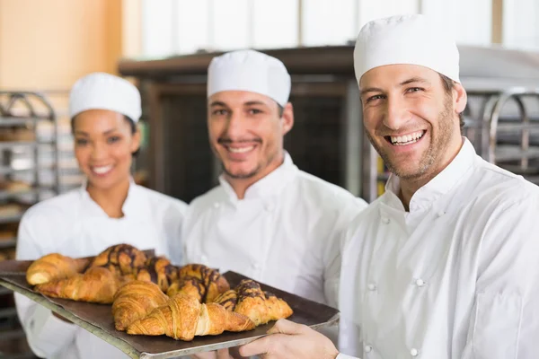 Boulangers souriant avec des plateaux de croissants — Photo