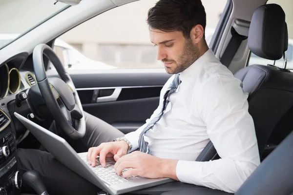 Businessman working in the drivers seat — Stock Photo, Image