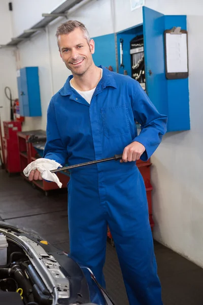 Mechanic checking the oil of car — Stock Photo, Image