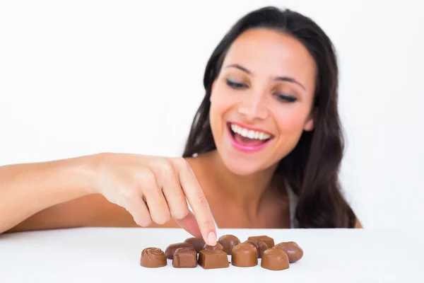 Morena bonita escolhendo chocolate — Fotografia de Stock