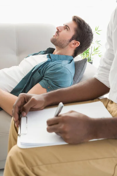 Terapeut tar anteckningar på sin orolig patient — Stockfoto