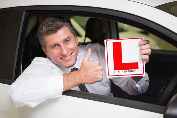 Homem gesticulando polegares para cima segurando um sinal de motorista aprendiz — Fotografia de Stock