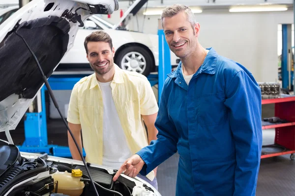 Mechanic showing customer the problem with car — Stock Photo, Image