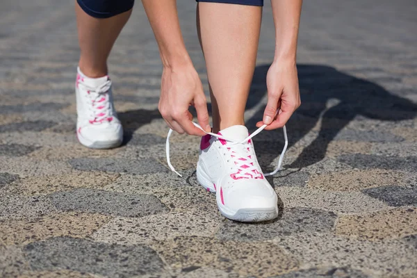 Vrouw koppelverkoop haar schoenveter op Sportschoen — Stockfoto