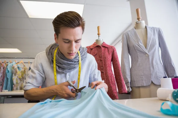 Student cutting fabric with pair of scissors — Stock Photo, Image