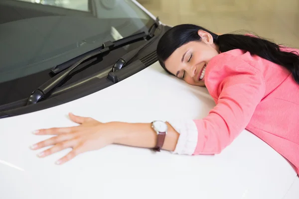 Smiling woman hugging a white car — Stock Photo, Image