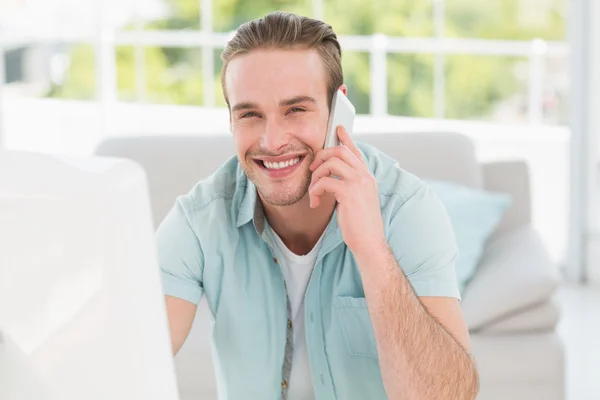 Businessman on phone using computer — Stock Photo, Image