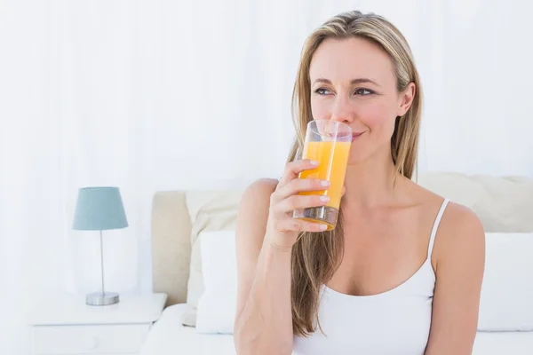 Blonde drinking glass of orange juice — Stock Photo, Image