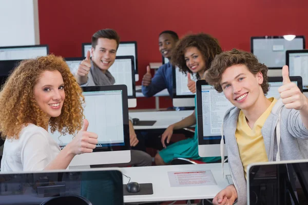 Estudantes sorrindo para a câmera na aula de informática — Fotografia de Stock