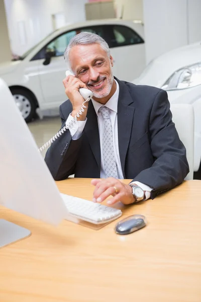 Улыбающийся бизнесмен делает телефонный звонок — стоковое фото