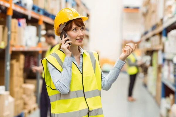 Warehouse manager talking on the phone looking around — Stock Photo, Image