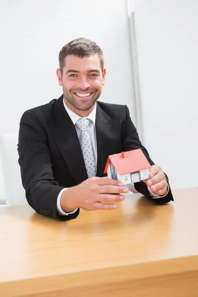 Empresário segurando um modelo de casa — Fotografia de Stock