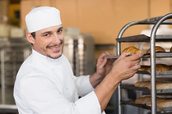 Piekarz sprawdzanie świeżo upieczony chleb — Zdjęcie stockowe