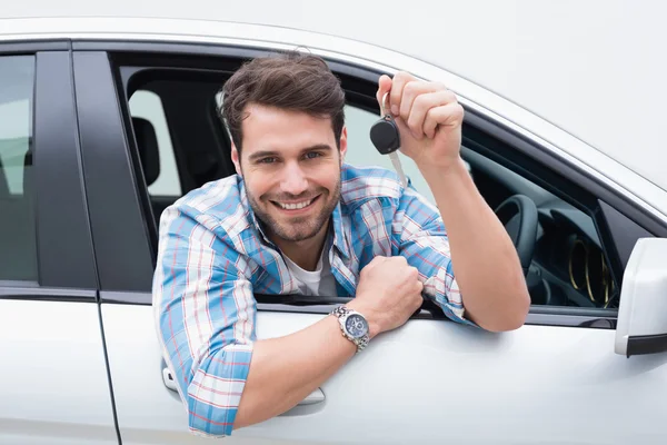 Junger Mann lächelt und zeigt Schlüssel — Stockfoto