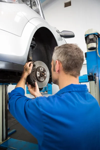 Focused mechanic adjusting the wheel — Stock Photo, Image
