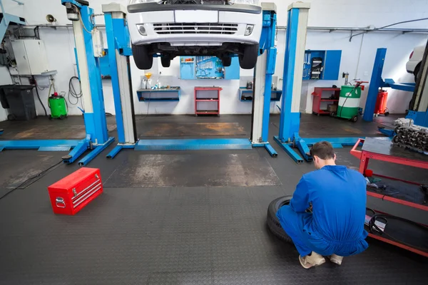 Mecânico trabalhando em uma roda de pneu — Fotografia de Stock