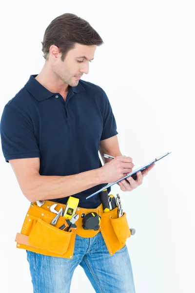 Carpenter writing on clipboard — Stock Photo, Image