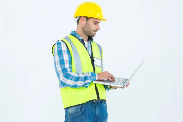 Repairman in reflective workwear using laptop — Stock Photo, Image