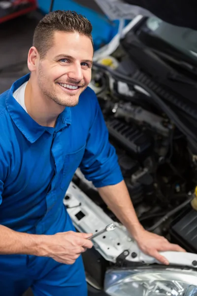 Smiling mechanic looking up at camera — Stock Photo, Image