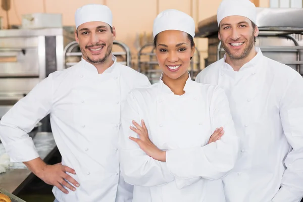 Team of bakers smiling at camera — Stock Photo, Image