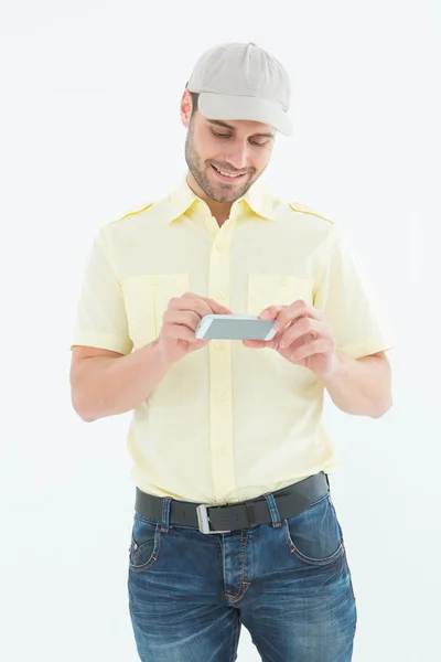 Gelukkig courier man met mobiele telefoon — Stockfoto