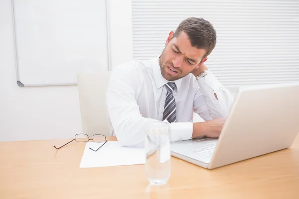 Confused businessman looking at his laptop — Stock Photo, Image