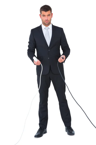 Serious businessman holding cables to connect — Stock Photo, Image