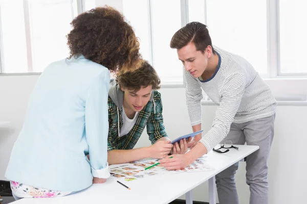 Students working with tablet pc and photos — Stock Photo, Image