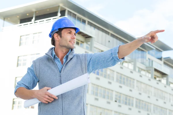 Architect with blueprint pointing away — Stock Photo, Image