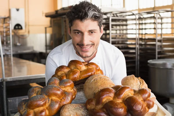 Usměvavá baker ukazuje představenstva chleby — Stock fotografie