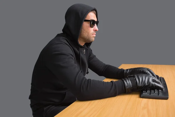 Serious burglar hacking into laptop — Stock Photo, Image