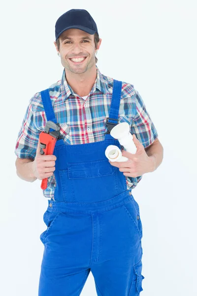 Plumber holding monkey wrench and sink pipe — Stock Photo, Image