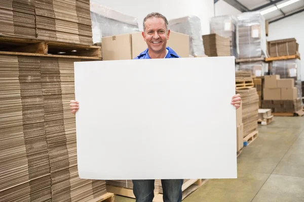Warehouse worker holding large poster — Stock Photo, Image