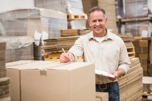 Warehouse worker checking his list — Stock Photo, Image