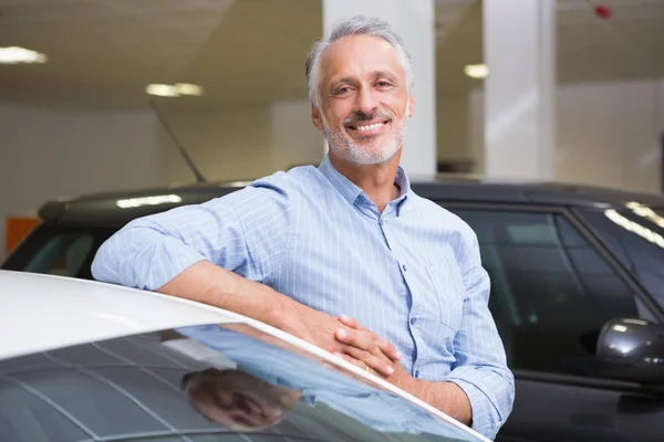 Smiling customer leaning on car — Stock Photo, Image