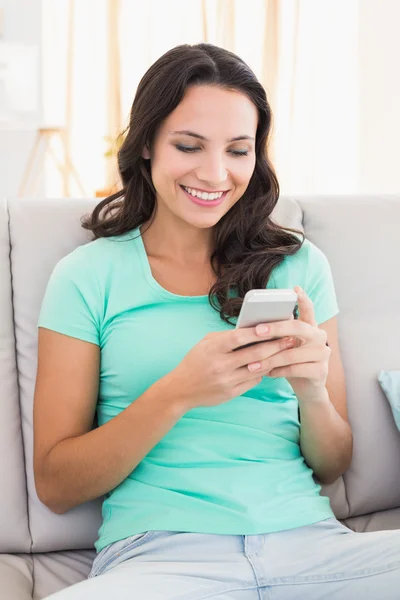 Mooie brunette SMS op de telefoon — Stockfoto