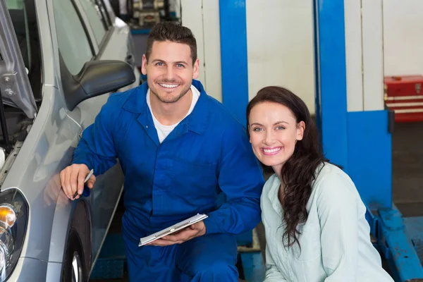 Mechaniker und Kunde lächeln in die Kamera — Stockfoto