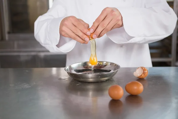 Baker cracking an egg in bowl — Stock Photo, Image