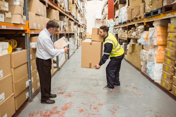 Manager titta på arbetstagare bära lådor — Stockfoto