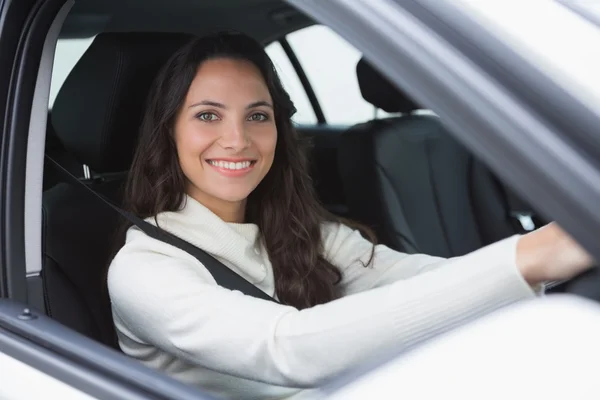 Красивая женщина улыбается и водит машину — стоковое фото